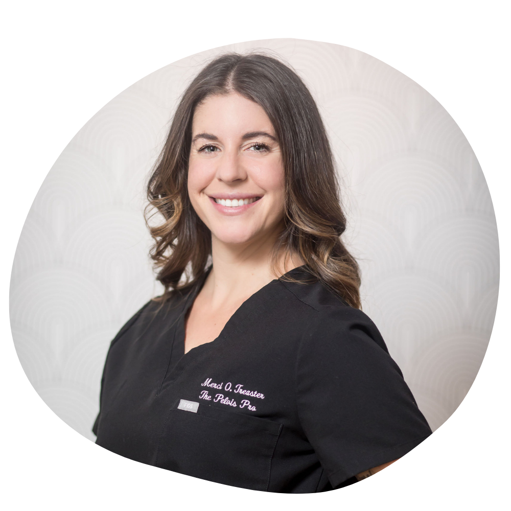 A woman in black scrubs with soft brown curls smiles at the camera. Her name is embroidered on the corner of her scrubs, reading Merci O. Treaster, The Pelvis Pro