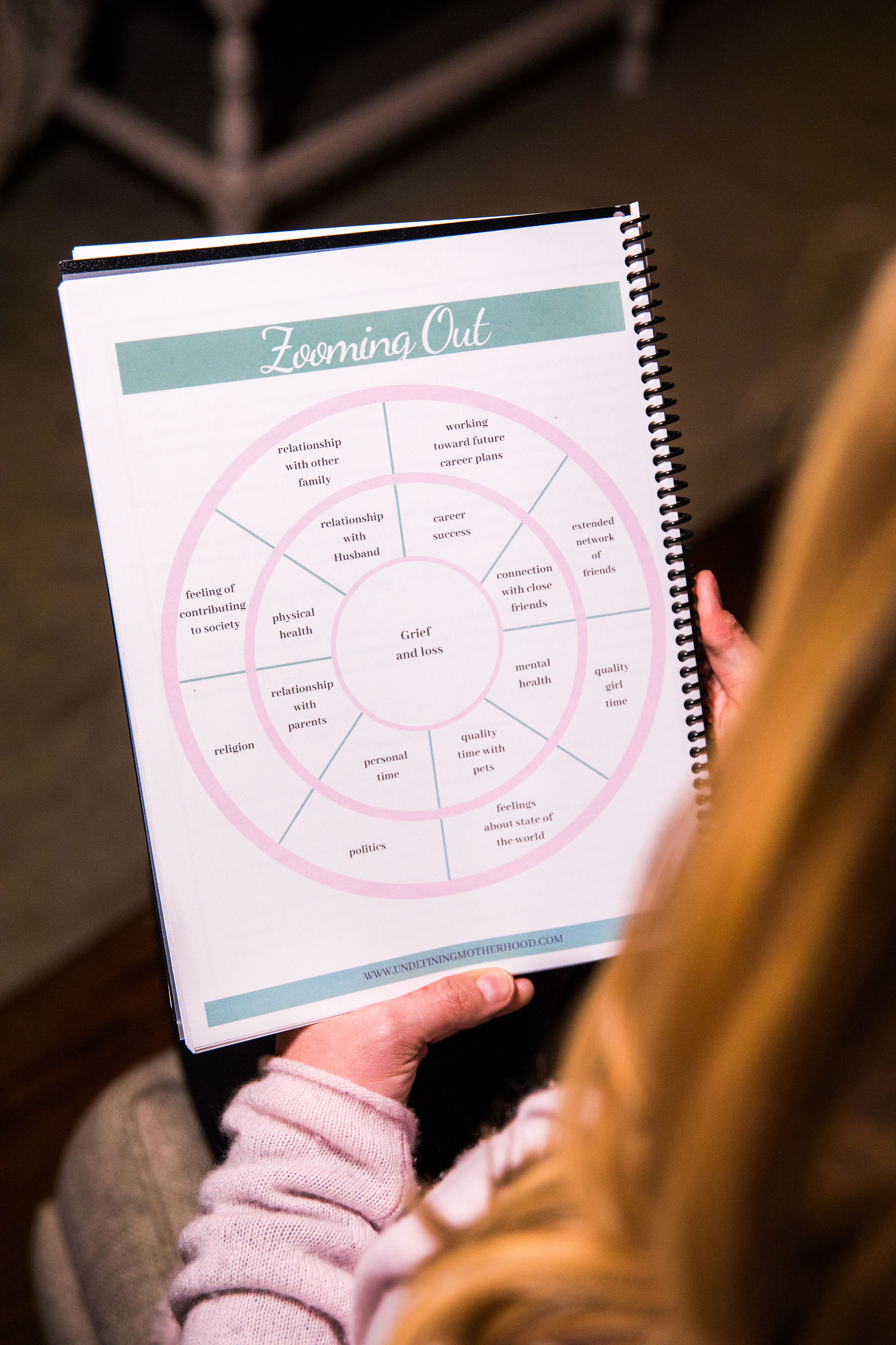 woman holding page from a miscarriage support journal helping people imagine the context of their larger lives