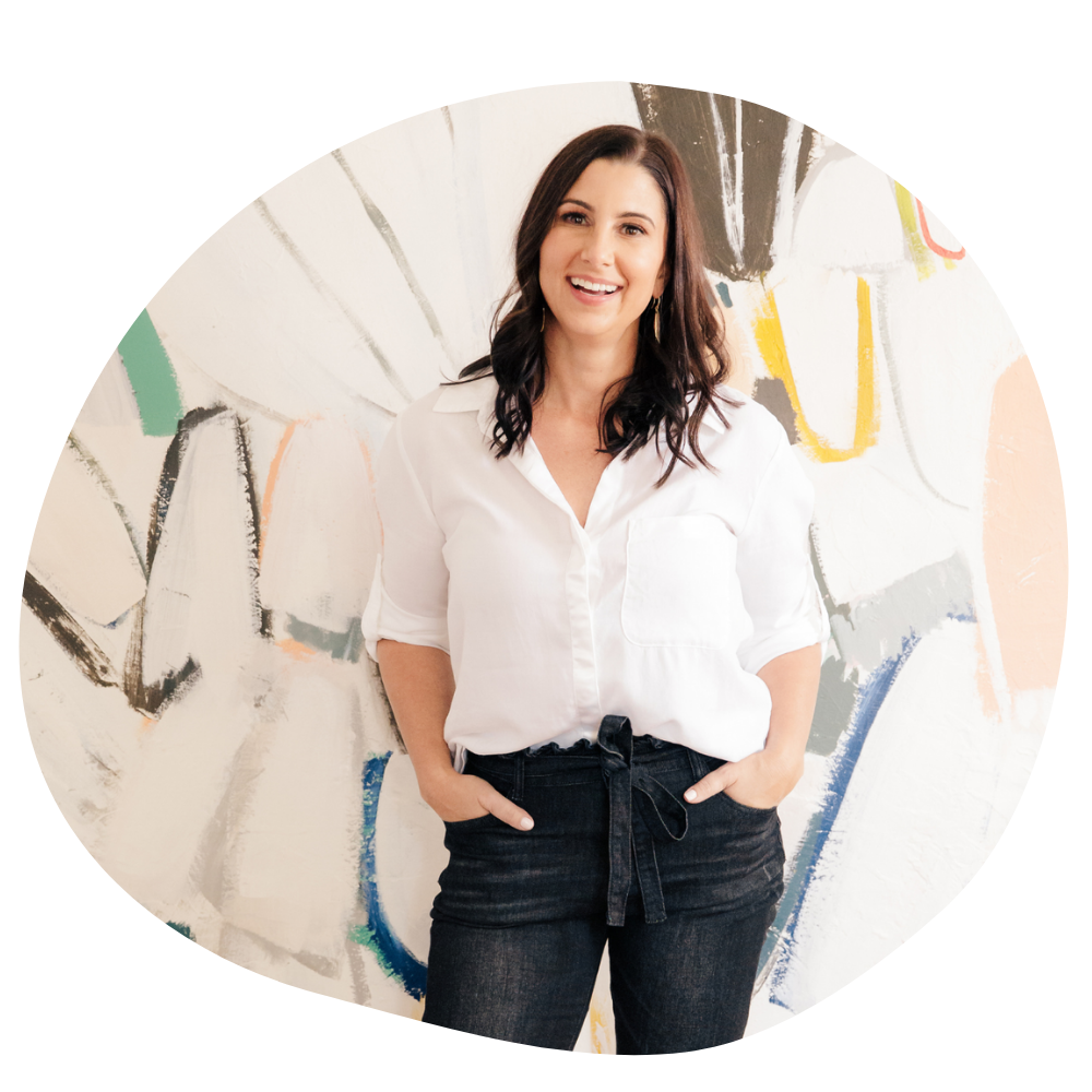 photo of a women with light skin and dark brown hair vibrantly smiling at the camera in front of a whimsical background with pastel-colored paint splatter